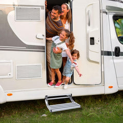 Electric RV step mounted under camper door